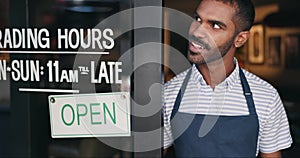 Open, sign and happy man at window of small business, coffee shop or start of service at restaurant. Store, notice and