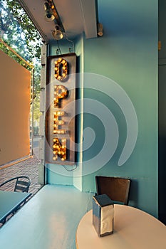 An OPEN sign inside restaurant with table