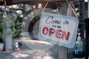 Open sign.Old rusty metal plate with word Come In We`re Open with alcohol gel photo