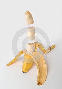 Open and sliced banana floating on white