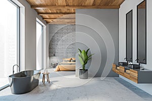 Open space living room, bedroom and bathtub with sinks.  Grey and brick walls