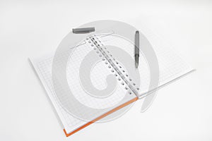 Open spiral-bound notebook with an orange cover, accompanied by a black pen, with copy space