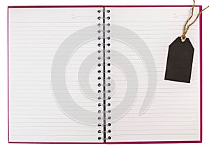 Open spiral notebook and black tag isolated on white