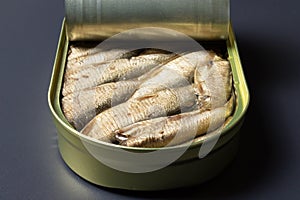 Open sprats can on dark background