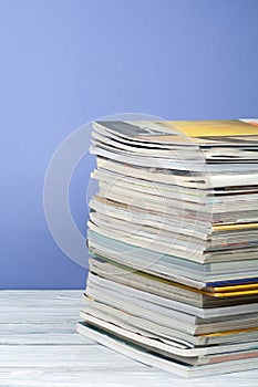 Open stacking book, hardback colorful books, magazine on wooden table and purple background. Back to school. Copy space