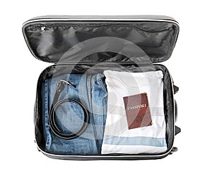 Open suitcase with packed things on white background, top view