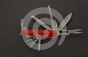 Open swiss army knife on a black background