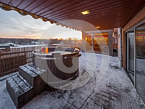 Open terrace with hot outdoor wooden bath tub. Luxury private house.