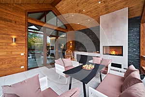 An open terrace with table, chairs, fireplace and apples