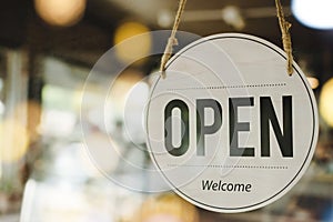 Open text on vintage sign board hanging on glass door with bokeh light