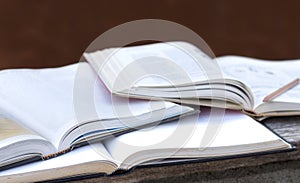 Open textbook and pencil on the wooden table. selective focused