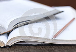 Open textbook and pencil on the wooden table. selective focused