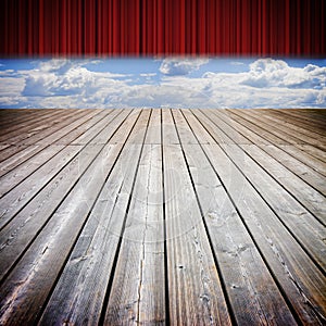 Open theater red curtains and wooden floor against a cloudy sky - concep timage