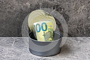 Open tin can with a one hundred Euro banknote