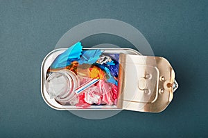 Open tin can. Plastic waste instead of fish inside. Ocean plastic pollution concept