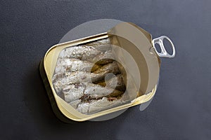 Open tin can of sardines with lid open and ring pull