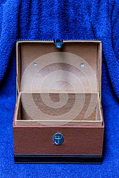 Open treasure chest box on blue cloth background