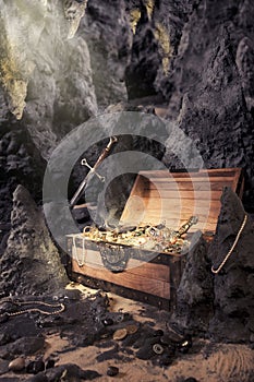 Open treasure chest with bright gold in a cave