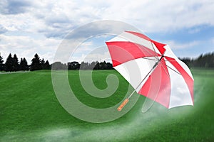 Open umbrella blown by wind gust outdoors