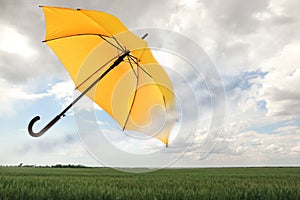 Open umbrella blown by wind gust outdoors