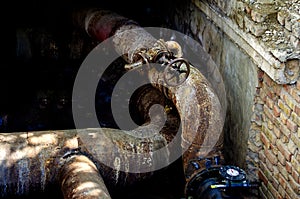 An open underground pipeline with valves in a brick well