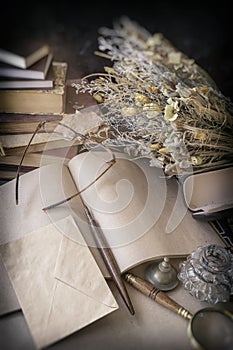 Open unwritten letter and envelope, glasses, books and a dried bouquet of flowers. Vintage style, nostalgia concept. photo