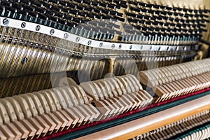 Open upright piano mechanism with strings and hammers.