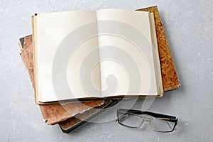 Open vintage book notepad with blank pages and glasses