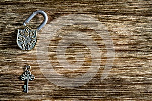 Open vintage padlock and old key on a wooden table