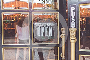 Open vintage sign broad through the glass of store window. Asia.