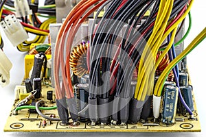 An open 220 volt computer power supply with visible wires coming out to power the computer components from the circuit board.