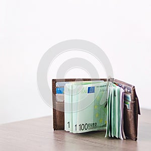 Open wallet with euro currency on the wooden table