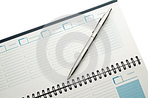 Open weekly planner with ballpen.