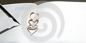 On the open weekly are two rings. They create a heart-shaped shadow.