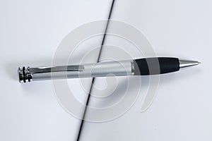 Open white blank book with a pen