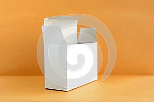 Open white cardboard box on light brown background