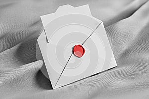 Open white envelope on gray tissue