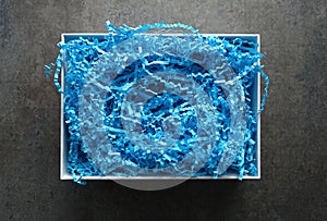 Open White Gift Box filled with Blue Crinkle Paper