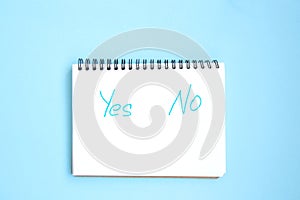 Open white notepad with inscriptions on a spiral on a bright blue background
