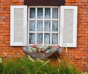 Open white window on red brick wall