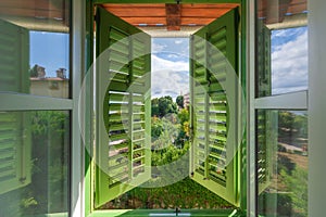 Open window with green wooden shutters with view of the Lovran, travel destination at Istrian seaside in Croatia