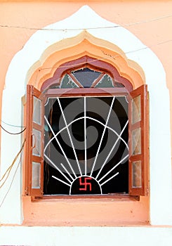 Open window of jain temple with ancient symbol of divinity and spirituality on it, India