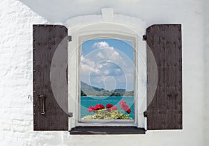 window in an old house decorated with flowers and sea view