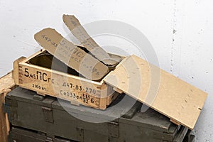 An open wooden box with Russian cartridges and ammunition on a light textured background, open zinc containers.