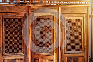 open wooden door with a grille to confessional booth for confession inside the Catholic church