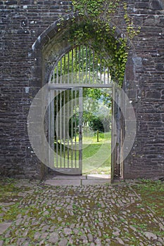 Open wooden gateway in arch of ancient priory in Brecon Beacons South Wales, UK