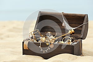 Open wooden treasure chest on sandy beach