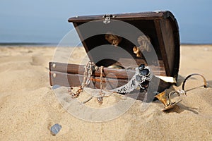 Open wooden treasure chest on sandy beach