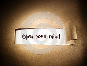 Open Your Mind appearing behind torn paper