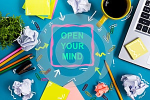 Open your mind. Office table desk with supplies, white blank note pad, cup, pen, pc, crumpled paper, flower on blue